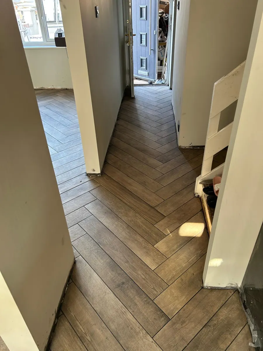 Herringbone wood-effect tile flooring continuing through to the hallway