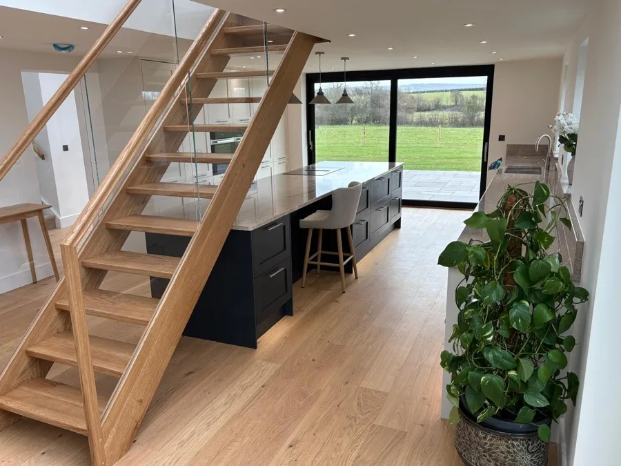 Solid oak flooring beneath an open-tread oak staircase