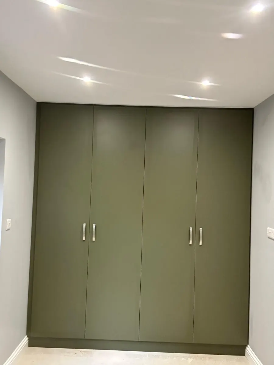 Olive green gloss fitted wardrobes in a bedroom