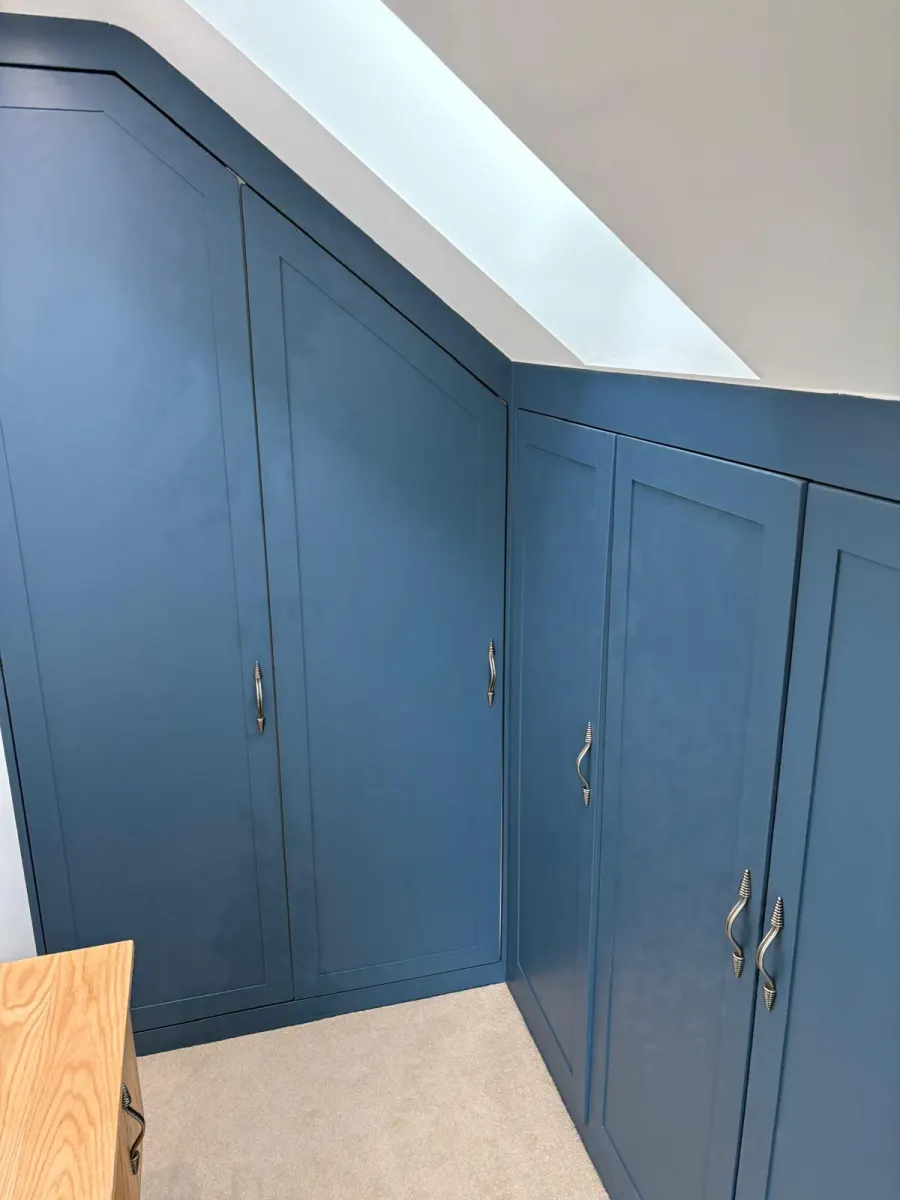 Fitted wardrobes built into a sloped eaves ceiling
