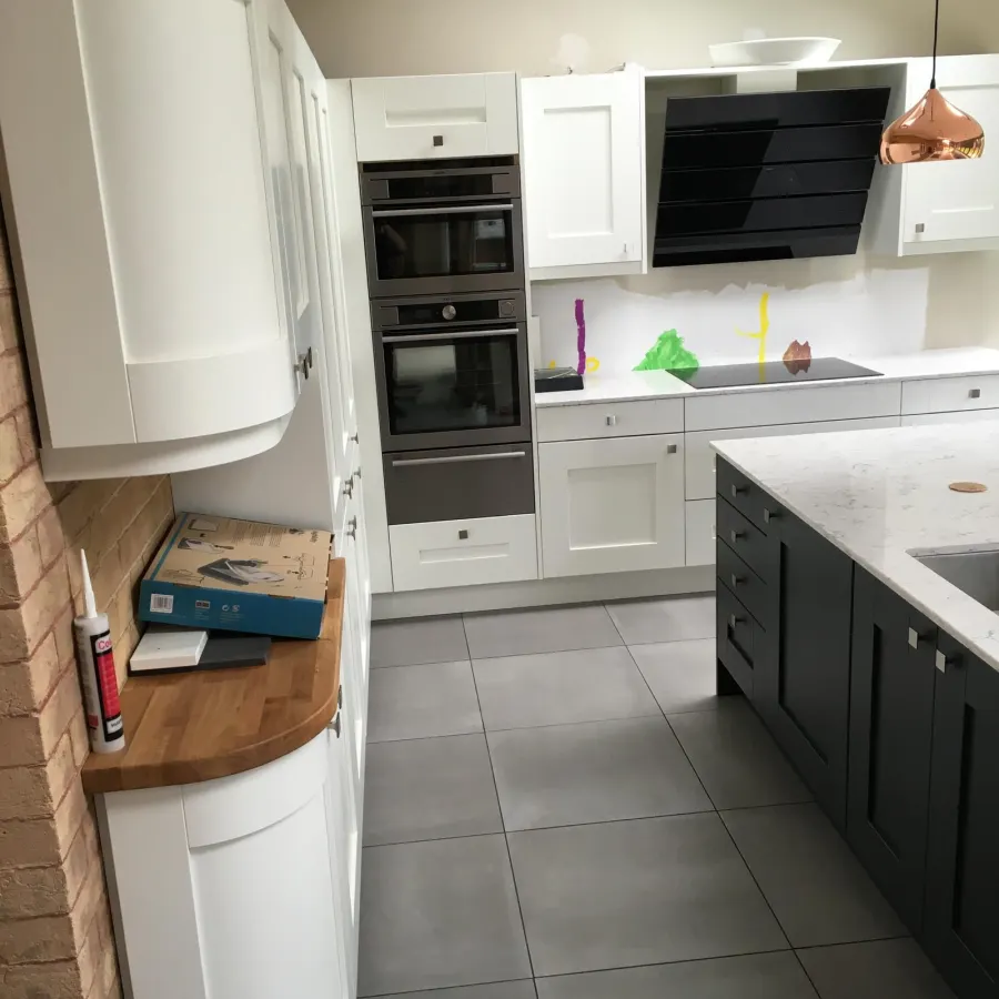 Shaker kitchen with matt black extractor hood and integrated ovens