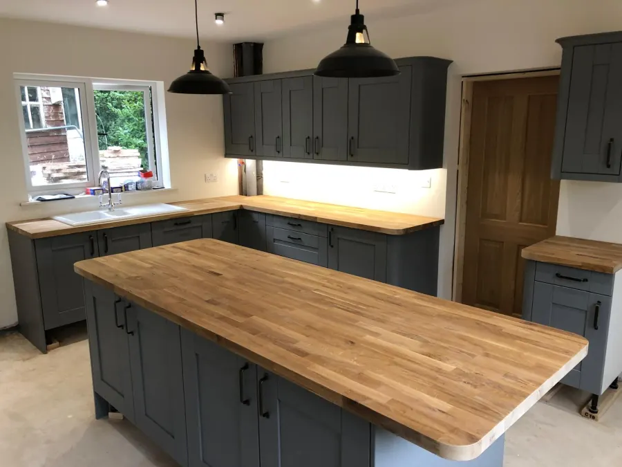 Navy island kitchen with dining area and bi-fold doors onto the garden