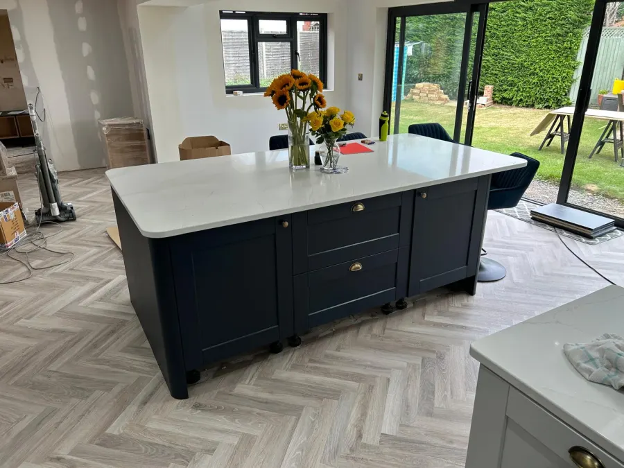 Open-plan kitchen with granite island, oak flooring and staircase, fitted by TF Fitting & Installation