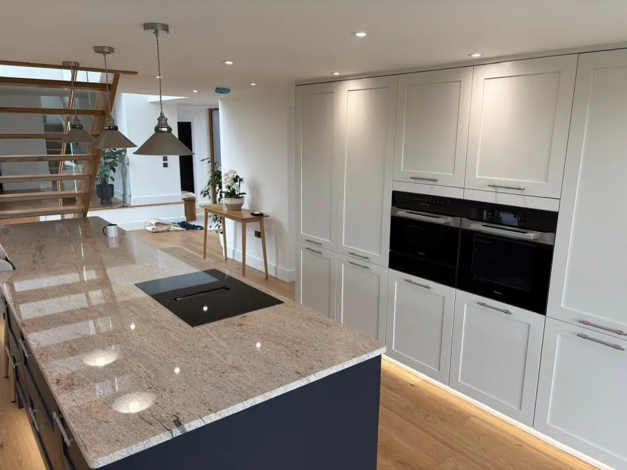 Floor-to-ceiling pale grey larder units with twin built-in ovens