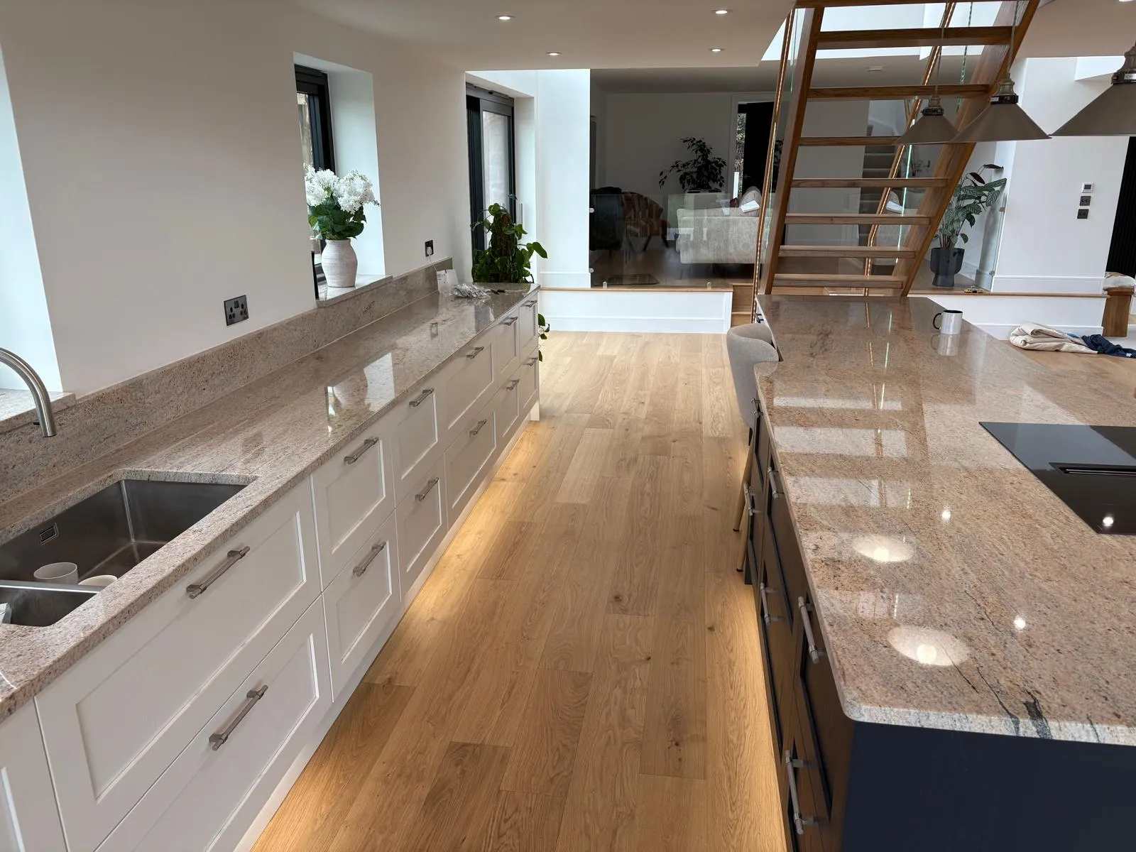 Open-plan kitchen with granite worktops, oak flooring and staircase, fitted by TF Fitting & Installation